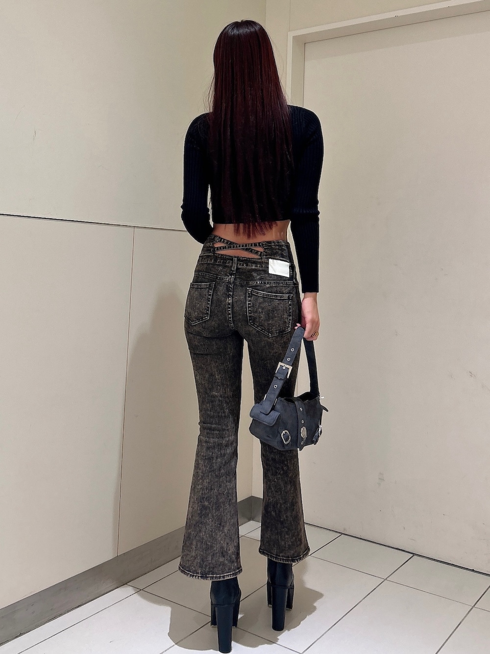 ブラック系のニット/セーター、ブルー系のデニムパンツ、グレー系のショルダーバッグを着用したレディースの秋コーディネートの3枚目の写真