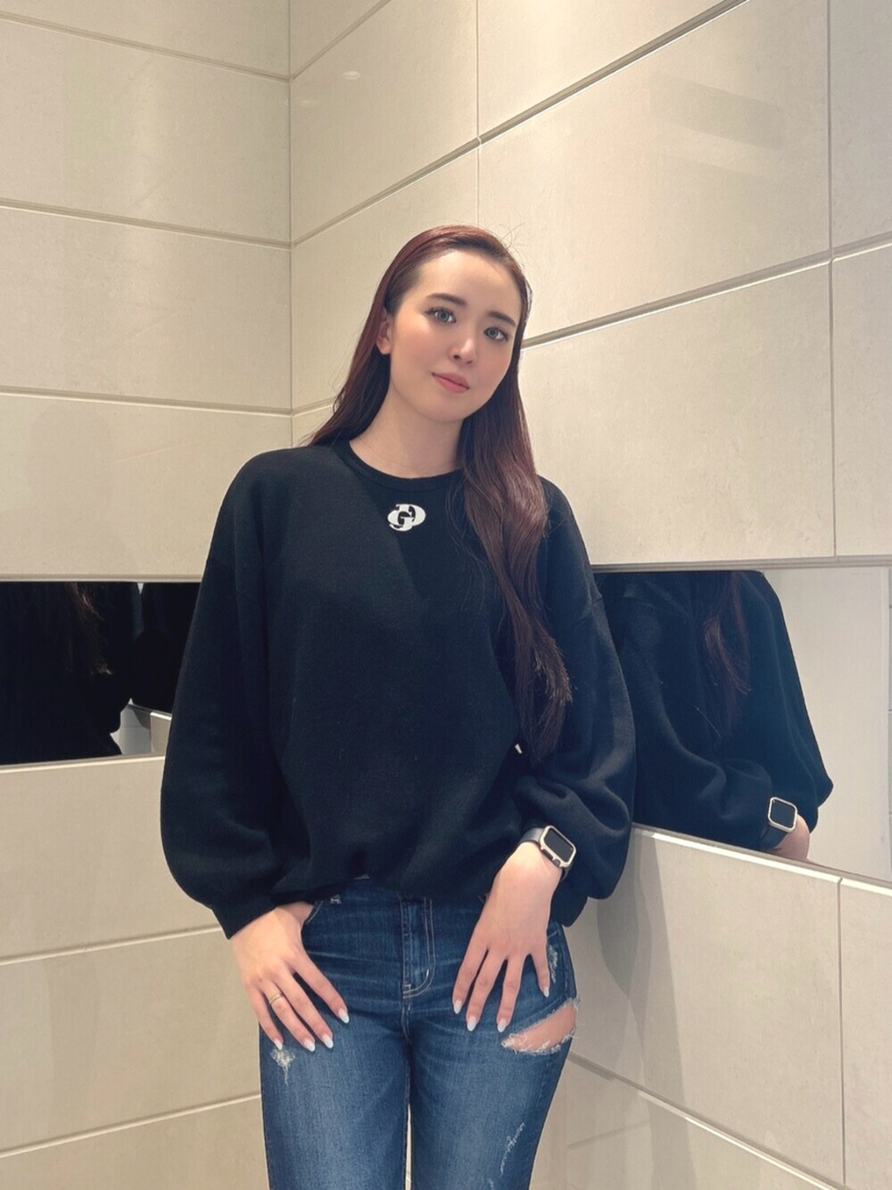 ブルー系のデニムパンツ、ホワイト系のパンプス、ブラック系のニット/セーターを着用したレディースの冬コーディネートの4枚目の写真