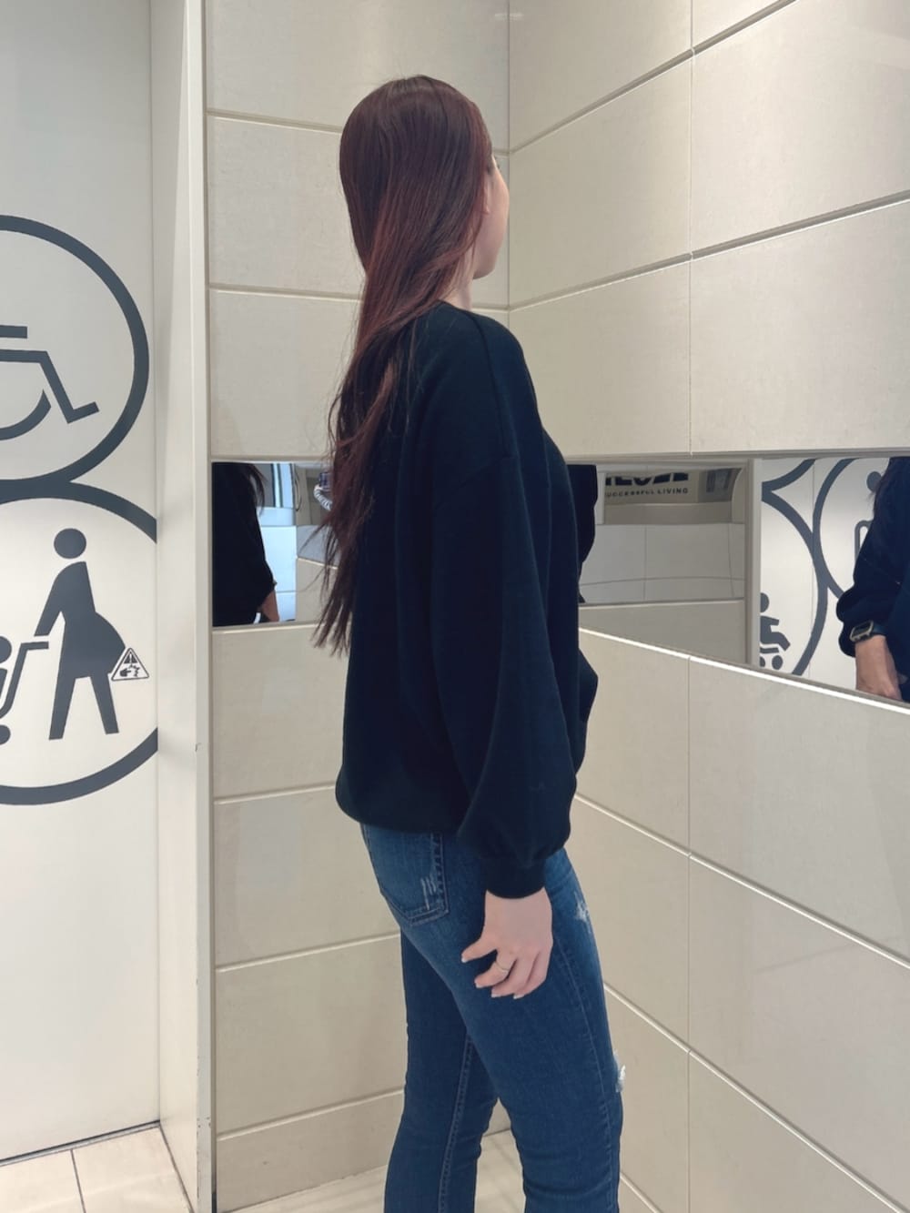 ブルー系のデニムパンツ、ホワイト系のパンプス、ブラック系のニット/セーターを着用したレディースの冬コーディネートの5枚目の写真