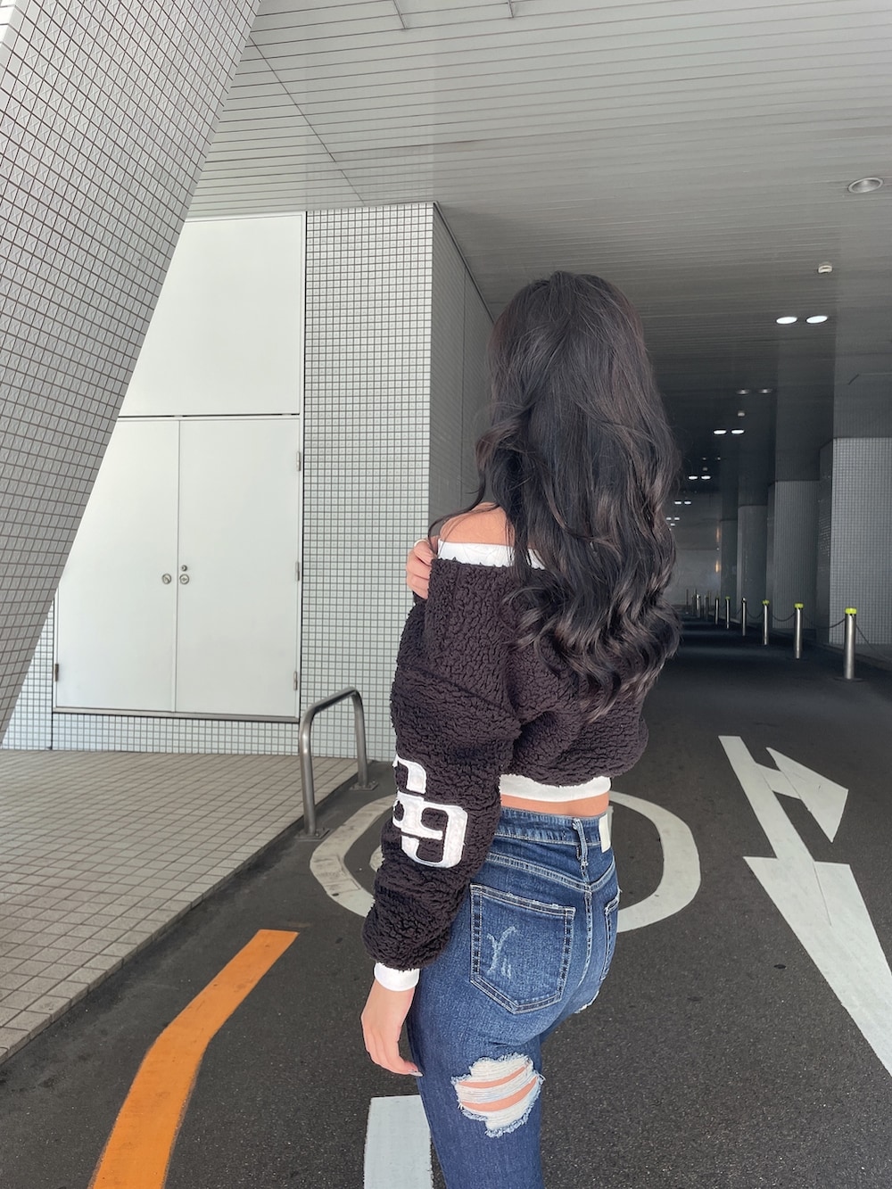 ブラック系のTシャツ/カットソー、ブルー系のデニムパンツ、ブラック系のブーツを着用したレディースの秋コーディネートの3枚目の写真