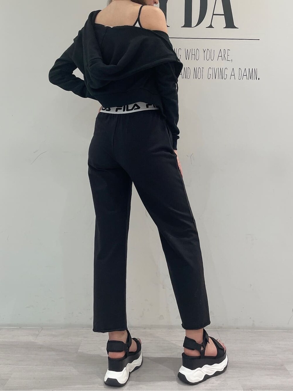 ブラック系のパーカー、グレー系のその他パンツ、ブラック系のキャミソールを着用したレディースの春コーディネートの5枚目の写真