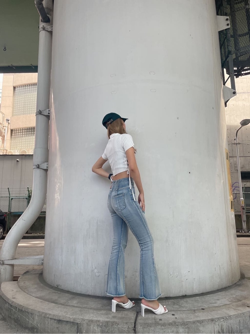 ホワイト系のニット/セーター、ホワイト系のサンダル、ブルー系のデニムパンツを着用したレディースの夏コーディネートの5枚目の写真