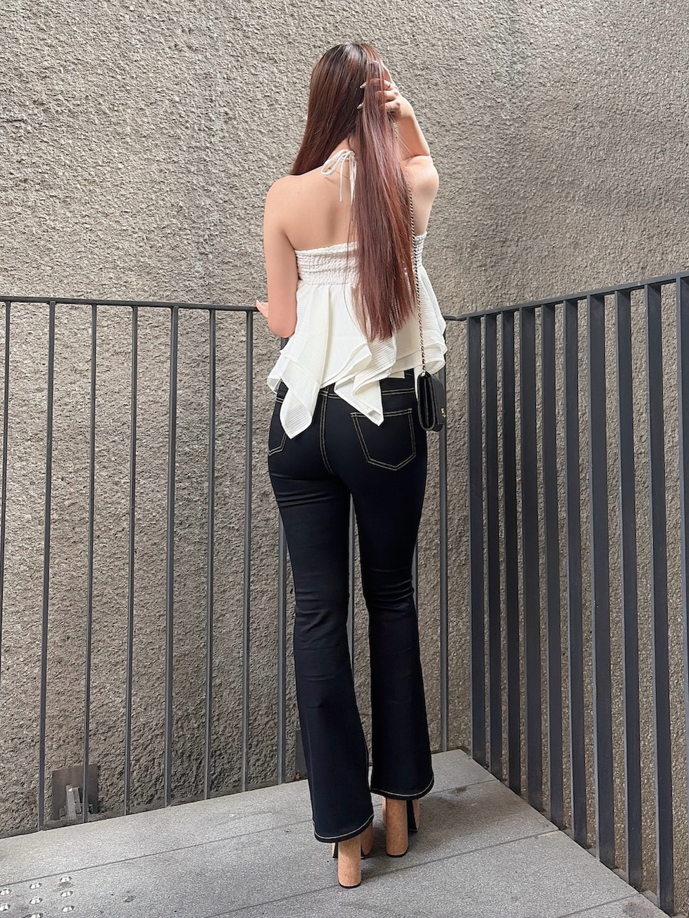 ホワイト系のキャミソール、ブラック系のデニムパンツ、ブラック系のサンダルを着用したレディースの夏コーディネートの3枚目の写真