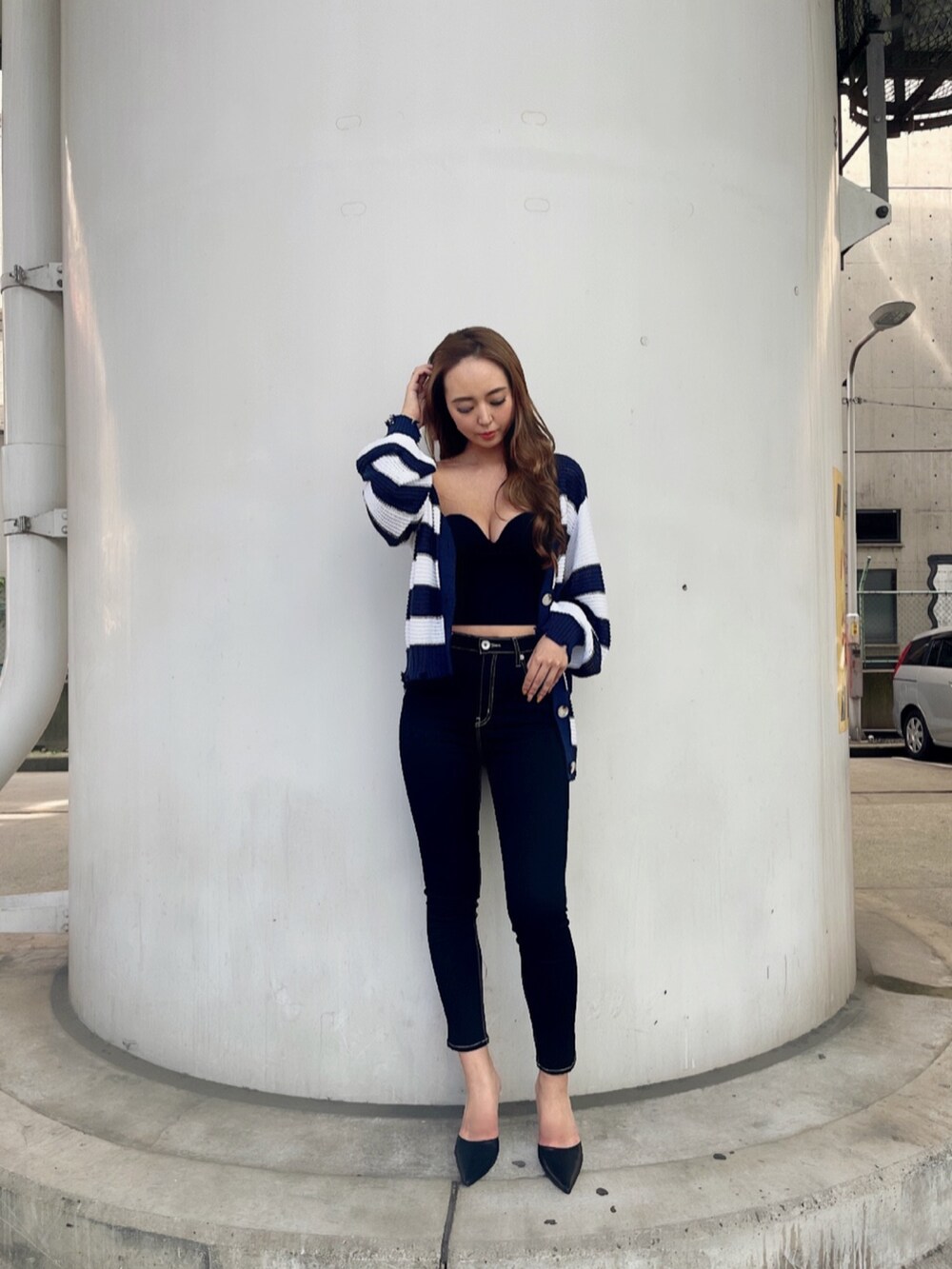 ブラック系のタンクトップ、ブルー系のデニムパンツ、ブラック系のパンプスを着用したレディースの夏コーディネートの2枚目の写真