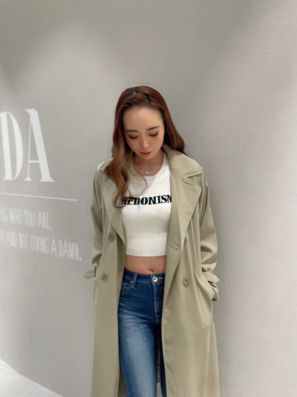 ブルー系のデニムパンツ、ホワイト系のTシャツ/カットソー、ベージュ系のトレンチコートを着用したレディースの春コーディネートの4枚目の写真