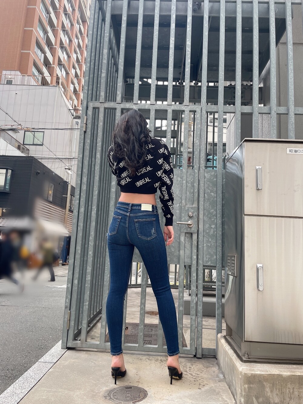 ブラック系のニット/セーター、ブルー系のデニムパンツ、ブラック系のパンプスを着用したレディースの冬コーディネートの3枚目の写真