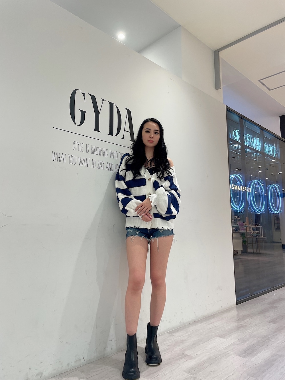 ブルー系のデニムパンツ、ブルー系のカーディガン/ボレロ、ブラック系のキャミソールを着用したレディースの春コーディネートの2枚目の写真