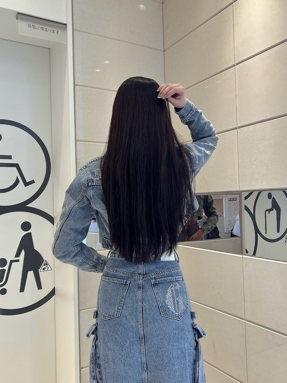 ホワイト系のスニーカー、ブルー系のデニムスカート、ブルー系のデニムジャケットを着用したレディースの冬コーディネートの6枚目の写真