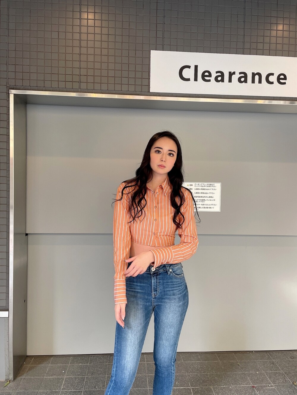 ブルー系のデニムパンツ、オレンジ系のシャツ/ブラウス、ブラック系のパンプスを着用したレディースの冬コーディネートの4枚目の写真