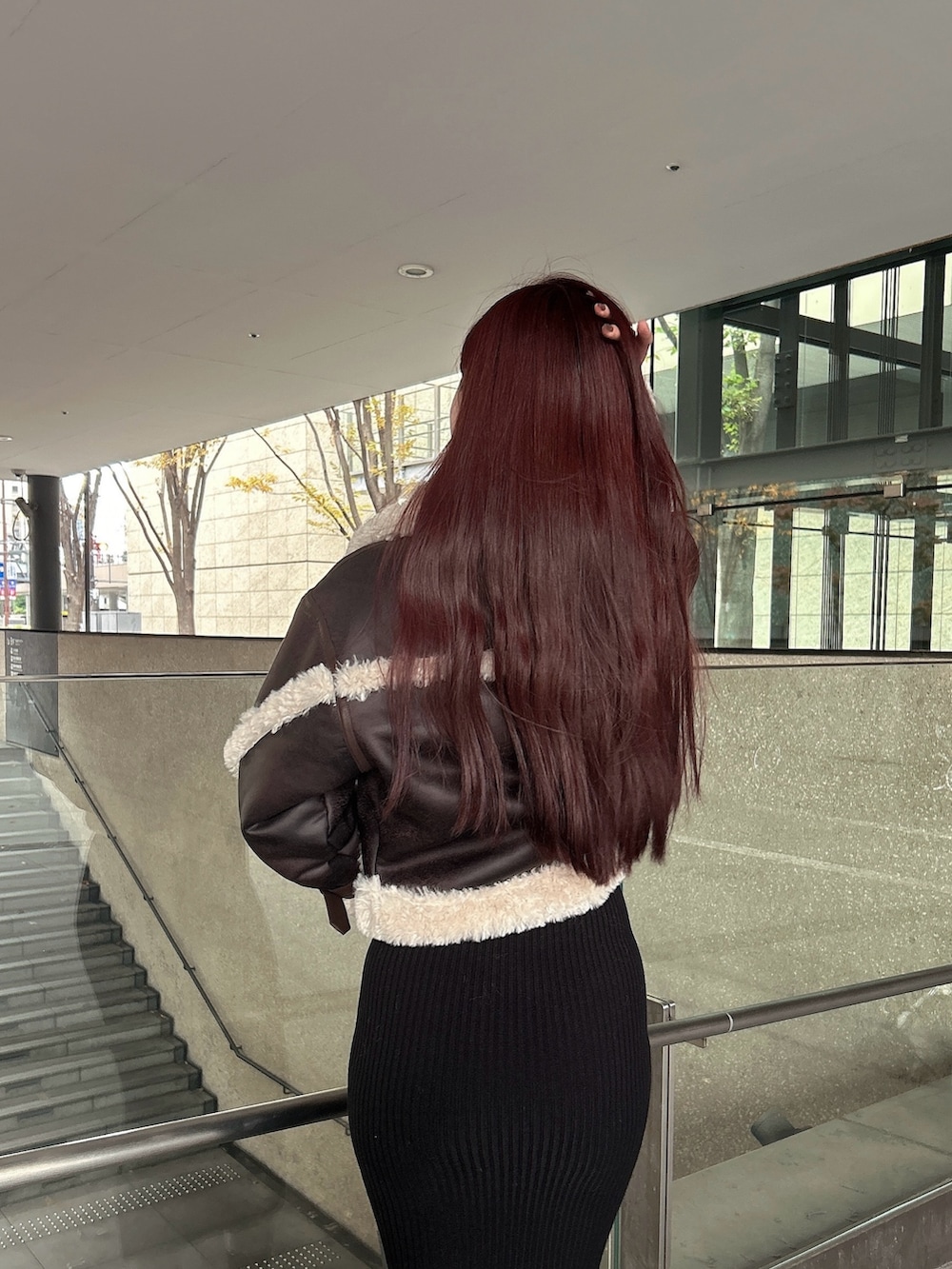 ブラウン系のムートンコート、ブラック系のブーツを着用したレディースの秋コーディネートの6枚目の写真