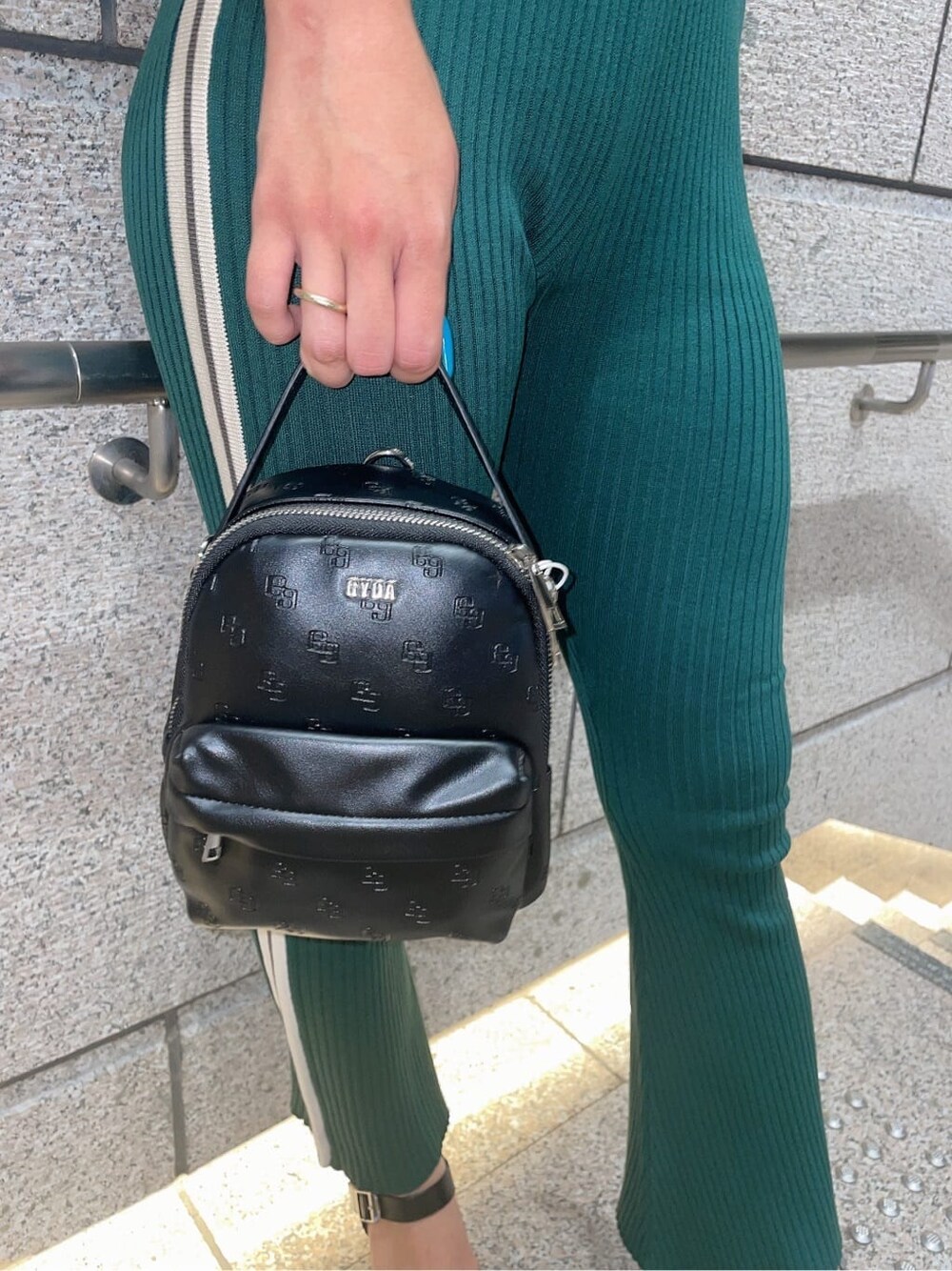 グリーン系のその他パンツ、グリーン系のニット/セーター、ブラック系のバックパック/リュックを着用したレディースの夏コーディネートの6枚目の写真