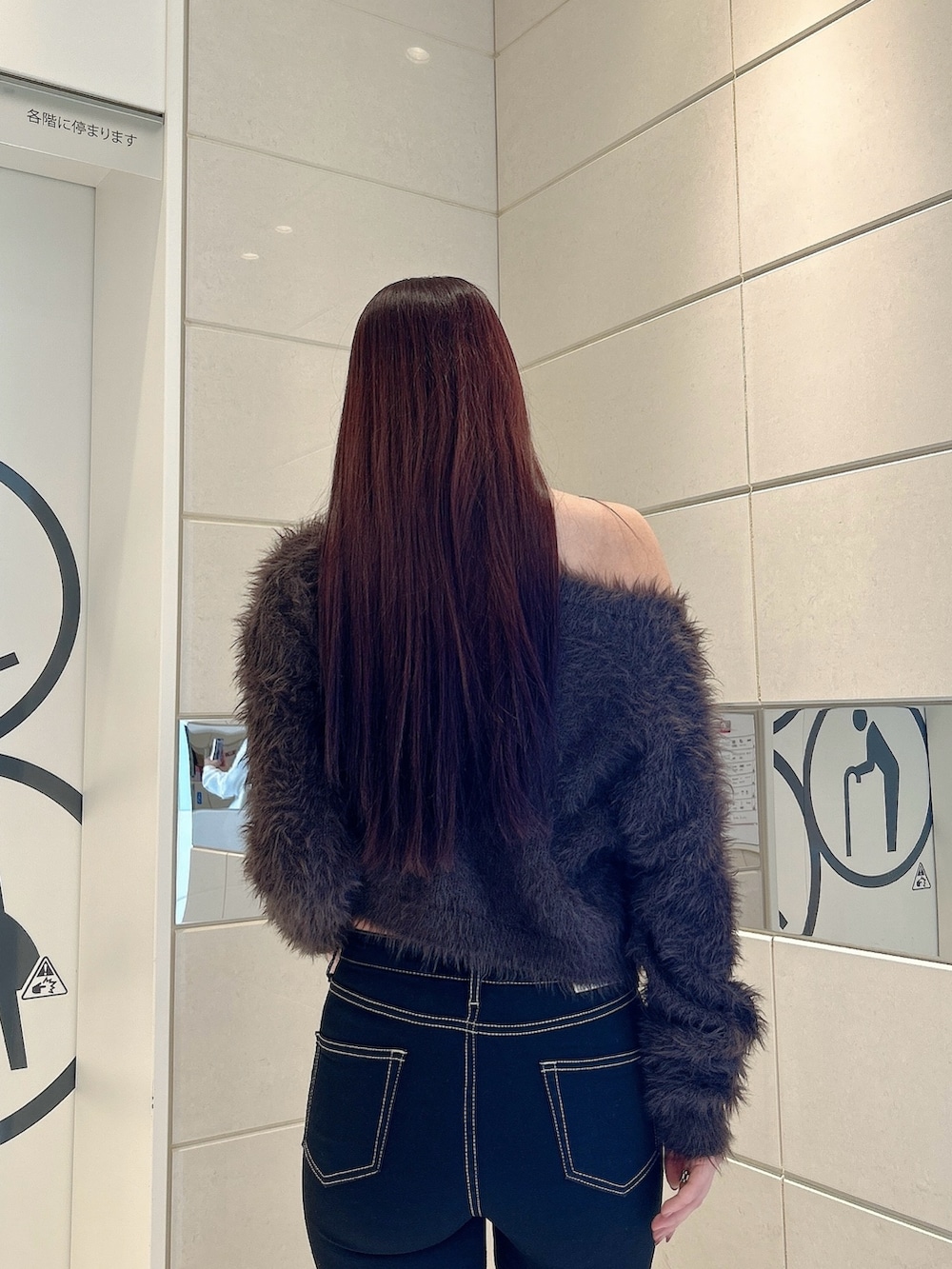 グレー系のニット/セーター、ブラック系のデニムパンツ、ブラック系のブーツを着用したレディースの冬コーディネートの6枚目の写真