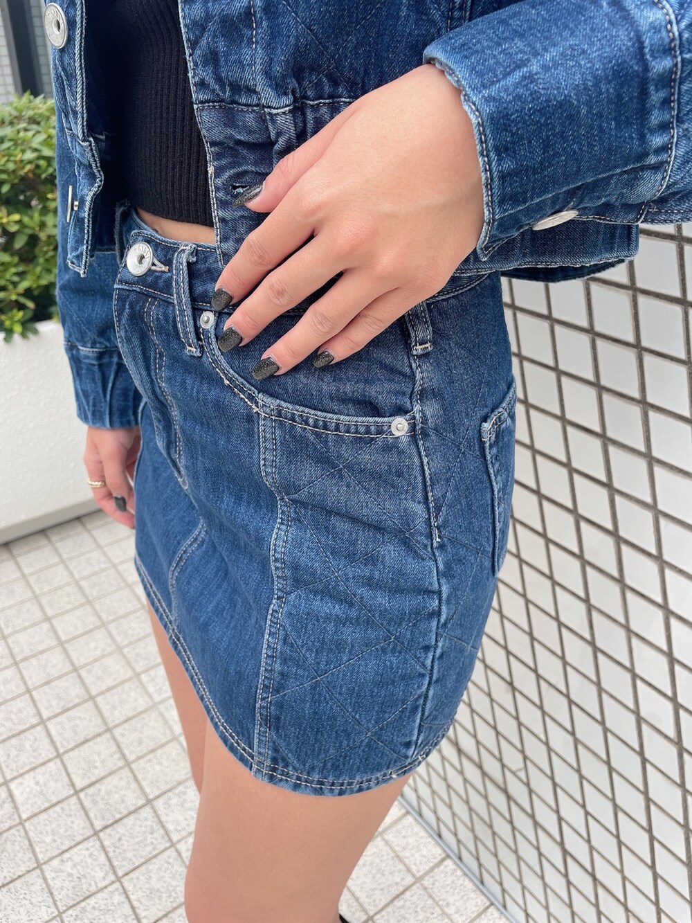 ブルー系のデニムジャケット、ブルー系のデニムスカート、ブラック系のニット/セーターを着用したレディースの秋コーディネートの6枚目の写真