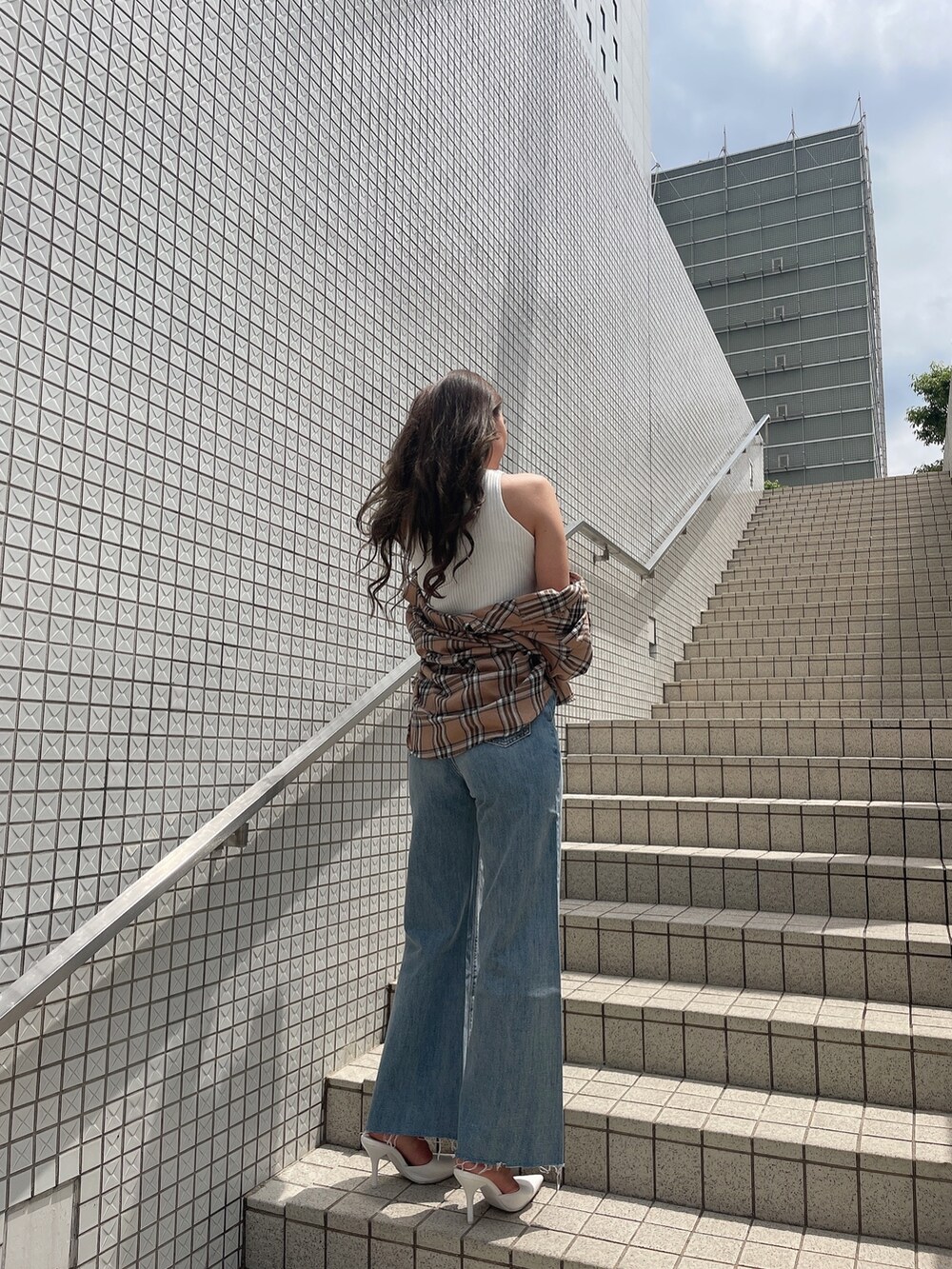 ベージュ系のシャツ/ブラウス、ホワイト系のタンクトップ、ブルー系のデニムパンツを着用したレディースの春コーディネートの3枚目の写真