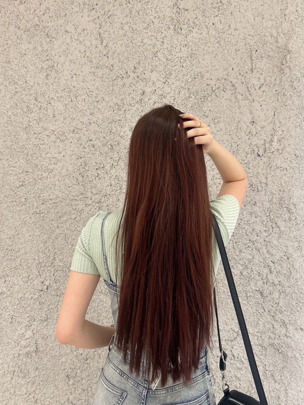 グリーン系のニット/セーター、ブルー系のつなぎ/オールインワン、ブラック系のバックパック/リュックを着用したレディースの春コーディネートの6枚目の写真