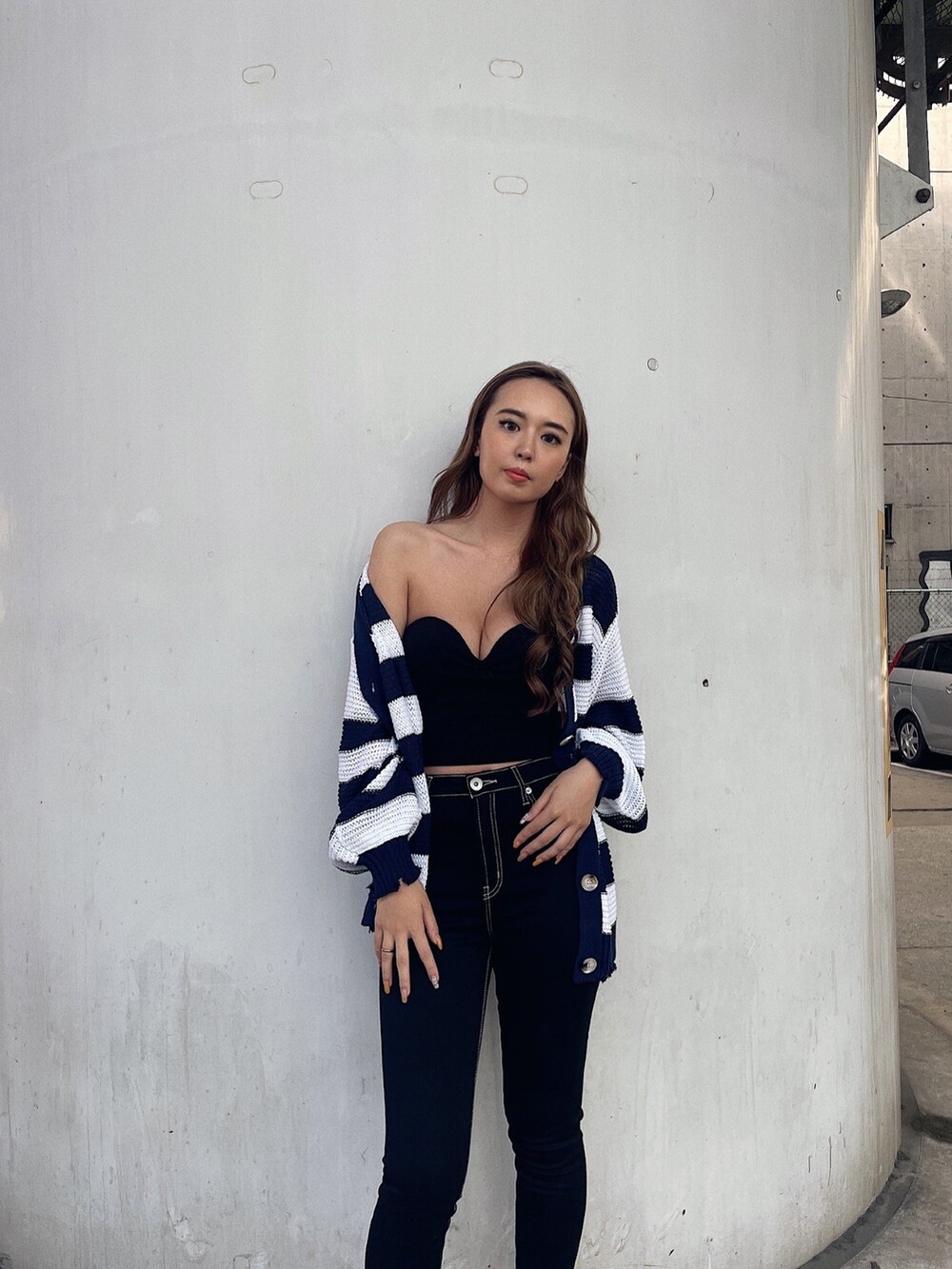 ブラック系のタンクトップ、ブルー系のデニムパンツ、ブラック系のパンプスを着用したレディースの夏コーディネートの3枚目の写真