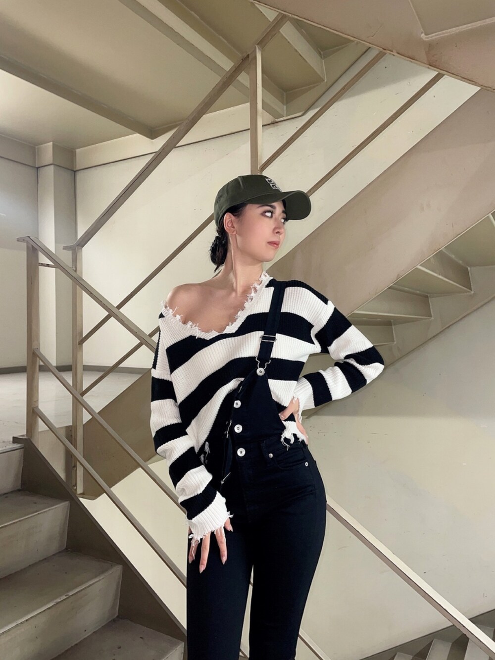 ブラック系のニット/セーター、ブラック系のサロペット/オーバーオール、ブラック系のパンプスを着用したレディースの冬コーディネートの5枚目の写真