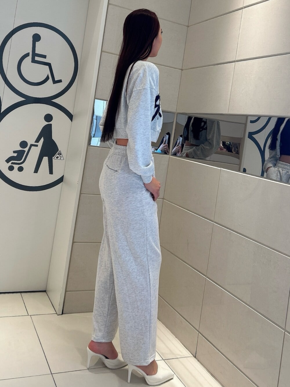 ホワイト系のパンプス、グレー系のスウェット、グレー系のスウェットパンツを着用したレディースの冬コーディネートの2枚目の写真