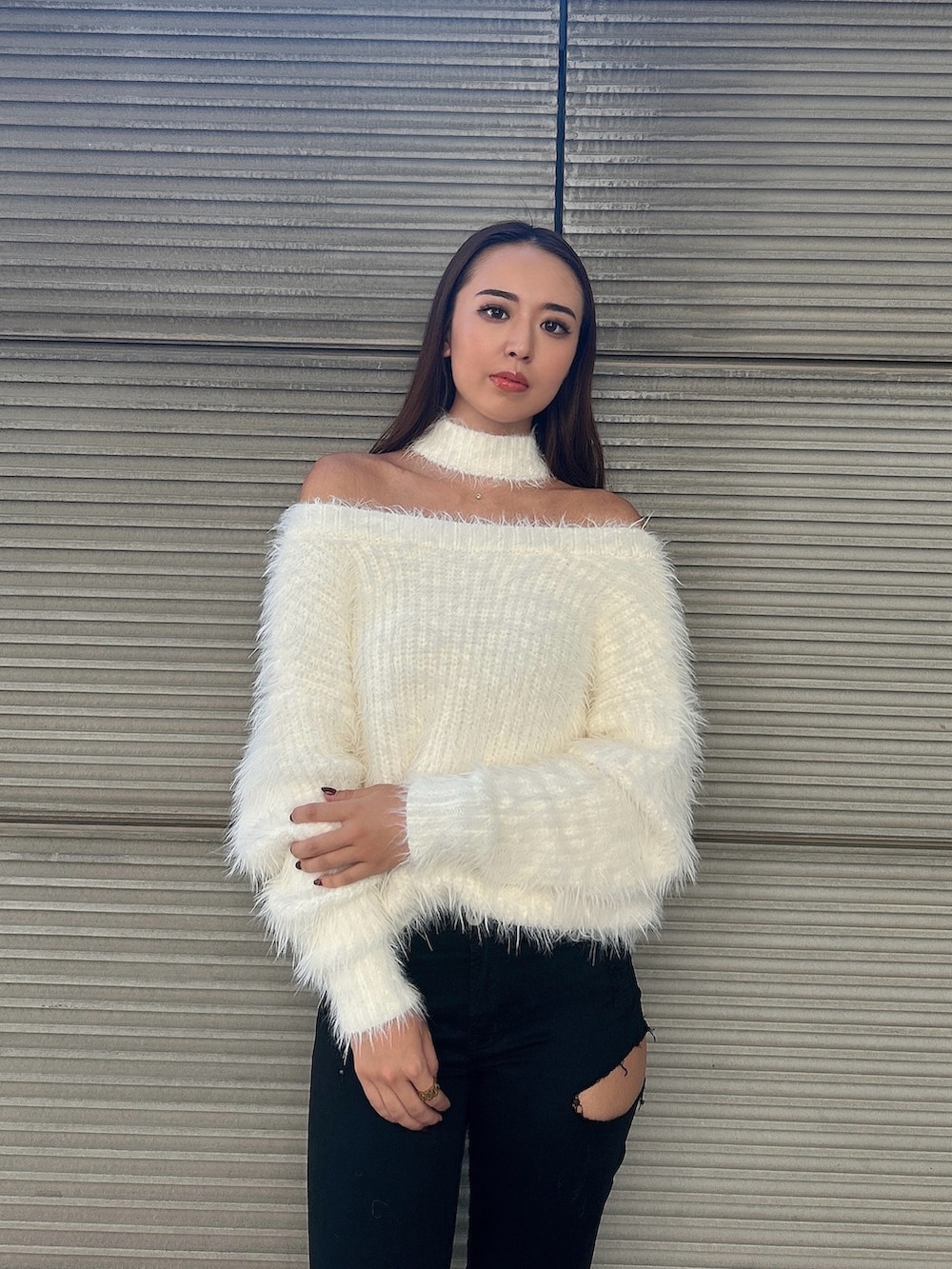 ホワイト系のニット/セーター、ブラック系のデニムパンツ、ブラック系のブーツを着用したレディースの秋コーディネートの4枚目の写真