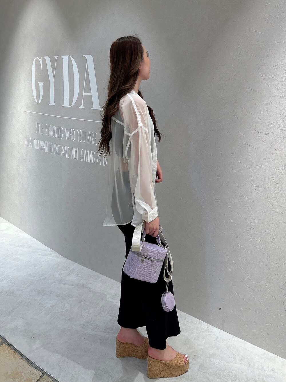 ホワイト系のシャツ/ブラウス、ブラック系のつなぎ/オールインワン、パープル系のハンドバッグを着用したレディースの春コーディネートの2枚目の写真