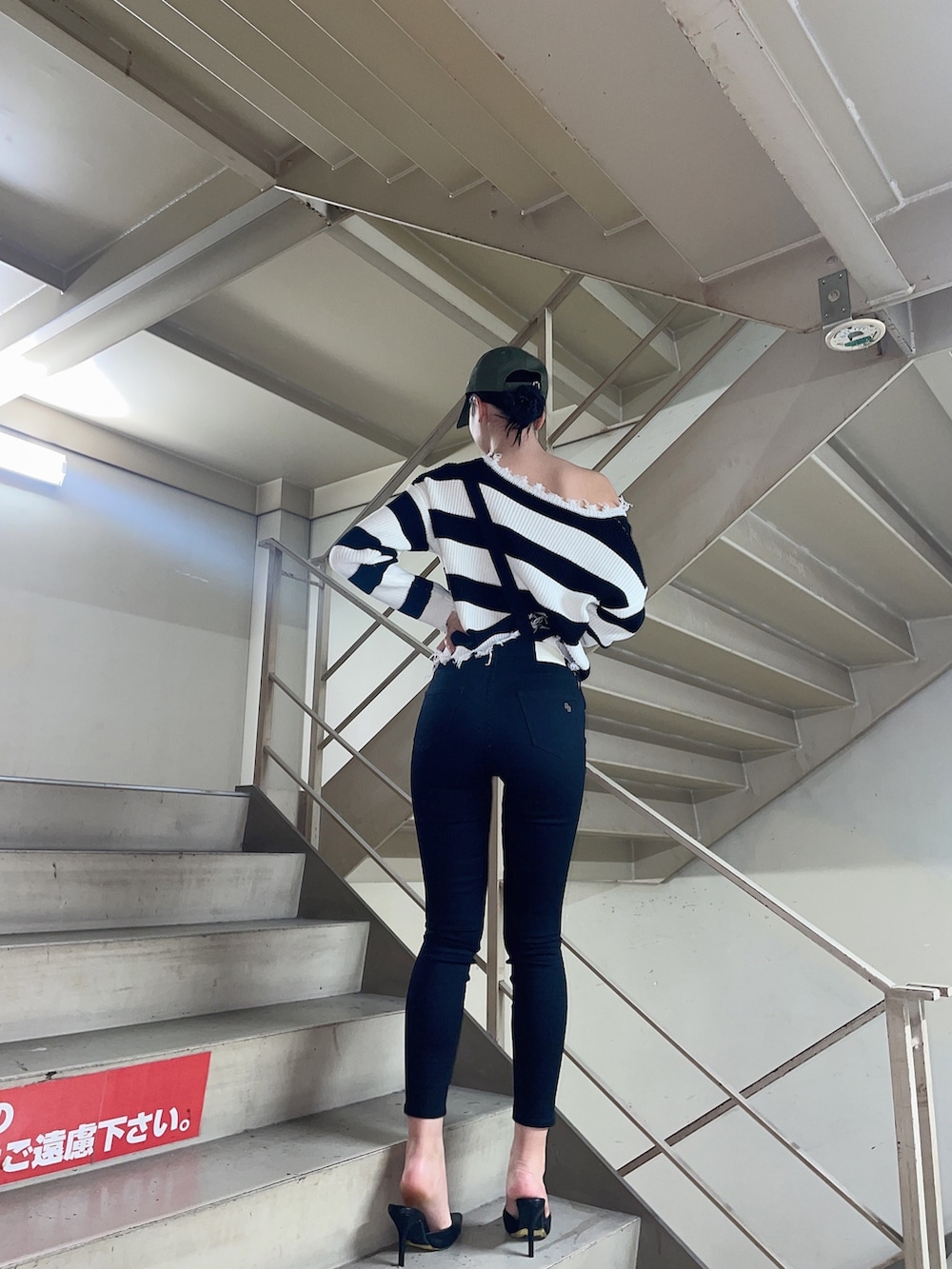 ブラック系のニット/セーター、ブラック系のサロペット/オーバーオール、ブラック系のパンプスを着用したレディースの冬コーディネートの2枚目の写真