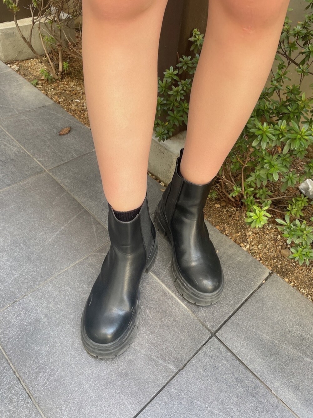 オレンジ系のスウェット、ブルー系のデニムパンツ、ブラック系のブーツを着用したレディースの冬コーディネートの8枚目の写真