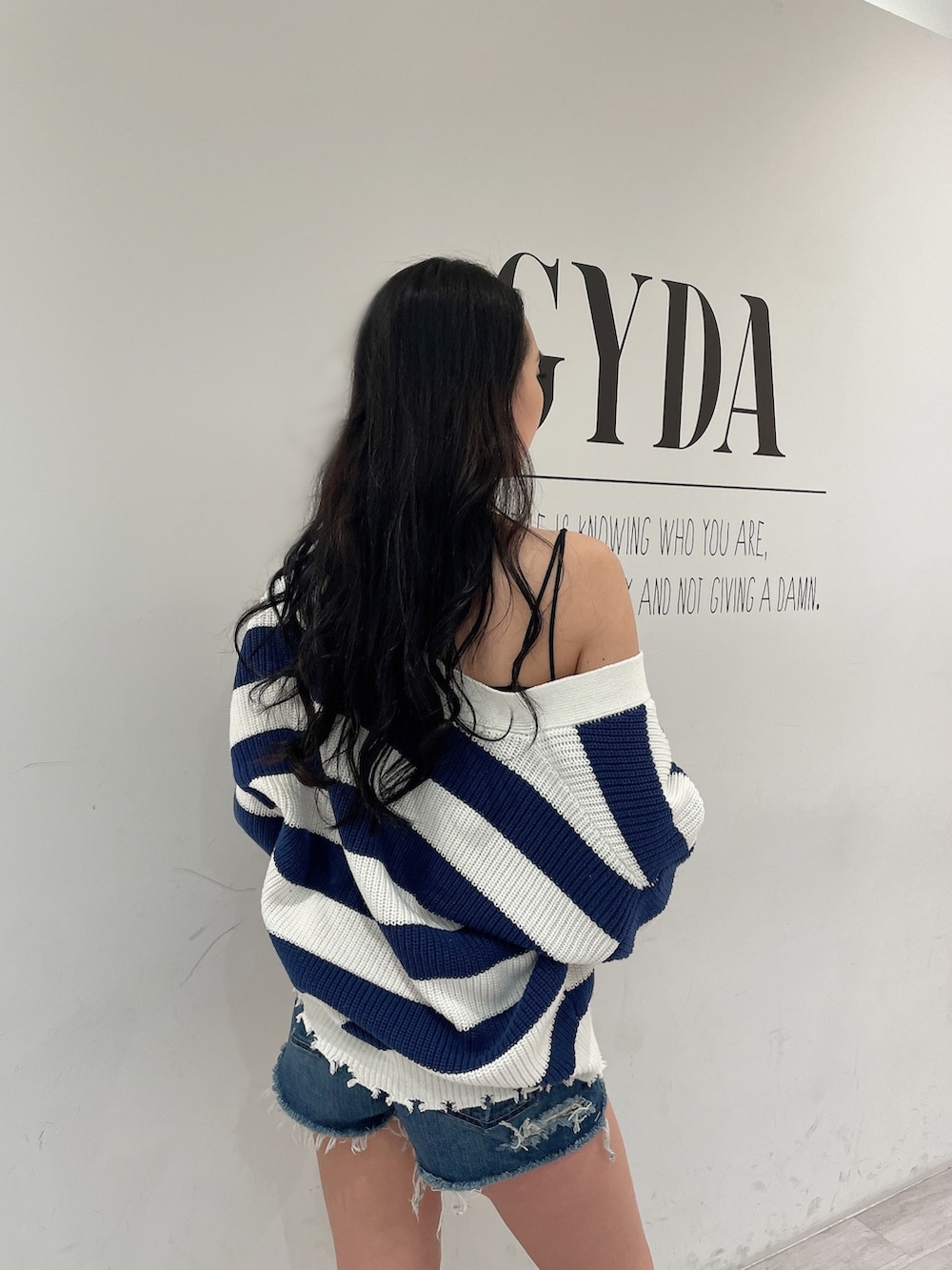 ブルー系のデニムパンツ、ブルー系のカーディガン/ボレロ、ブラック系のキャミソールを着用したレディースの春コーディネートの5枚目の写真