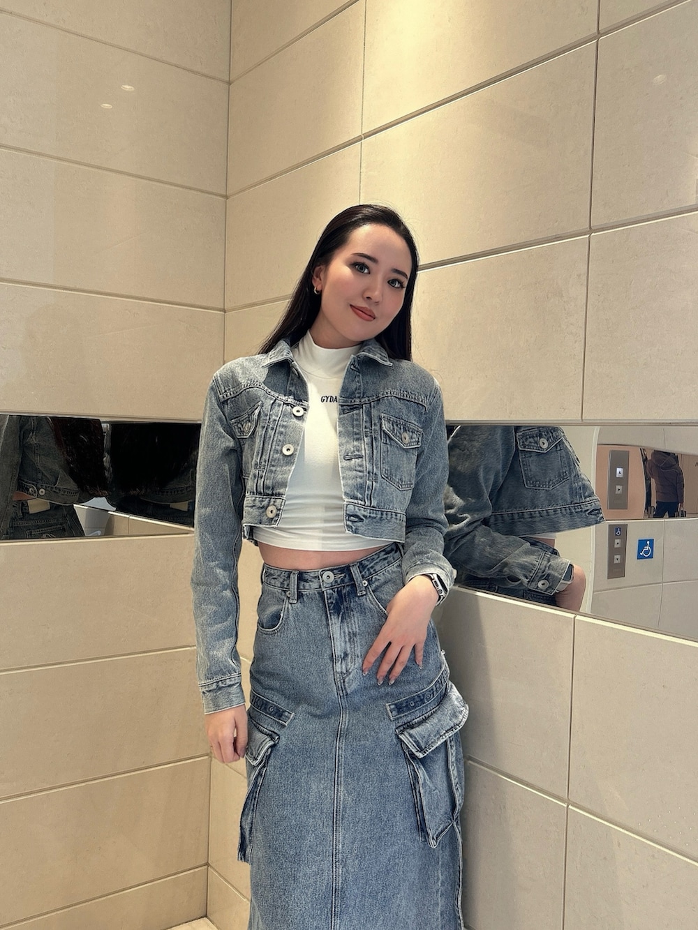 ホワイト系のスニーカー、ブルー系のデニムスカート、ブルー系のデニムジャケットを着用したレディースの冬コーディネートの4枚目の写真