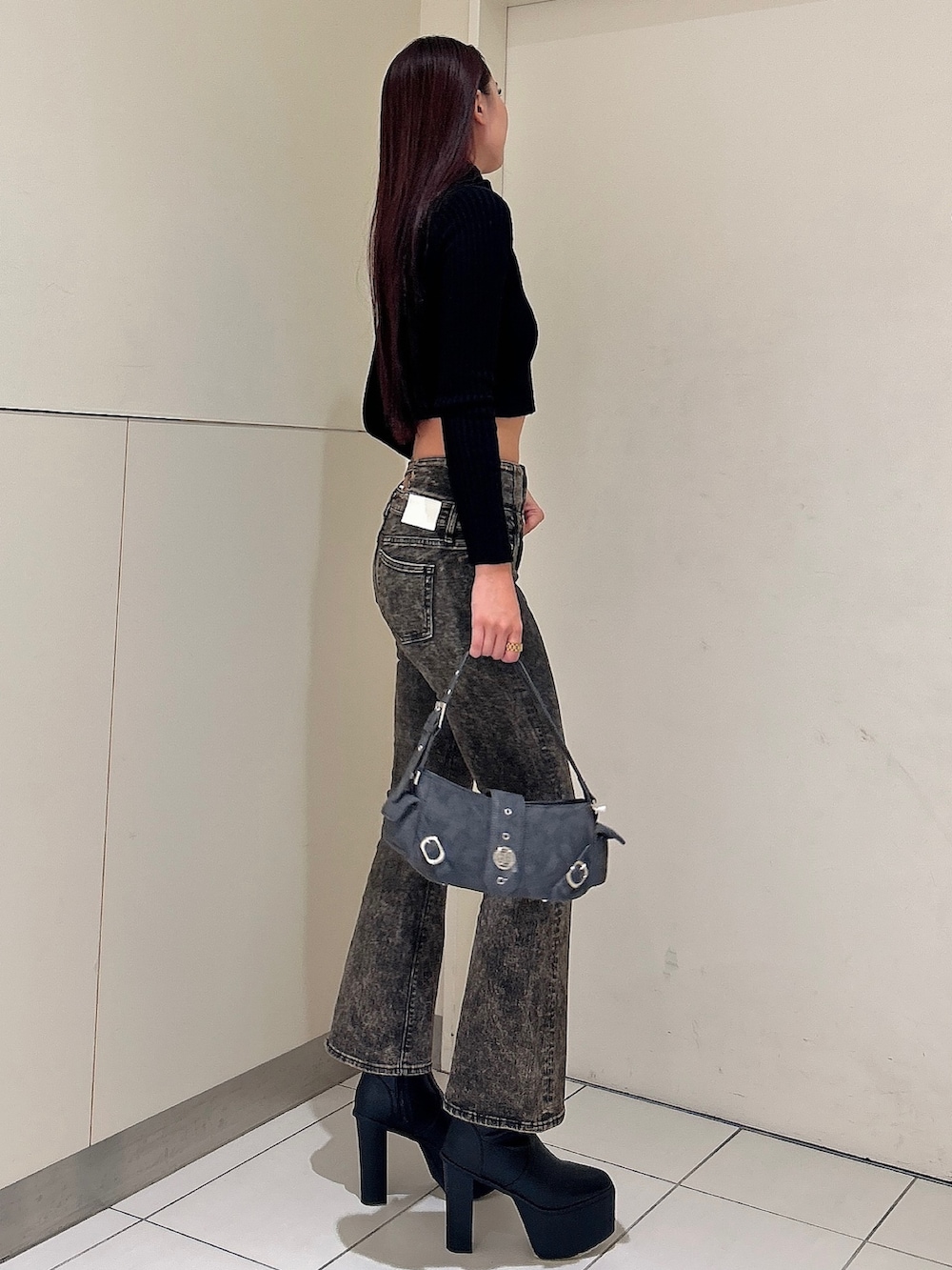 ブラック系のニット/セーター、ブルー系のデニムパンツ、グレー系のショルダーバッグを着用したレディースの秋コーディネートの2枚目の写真