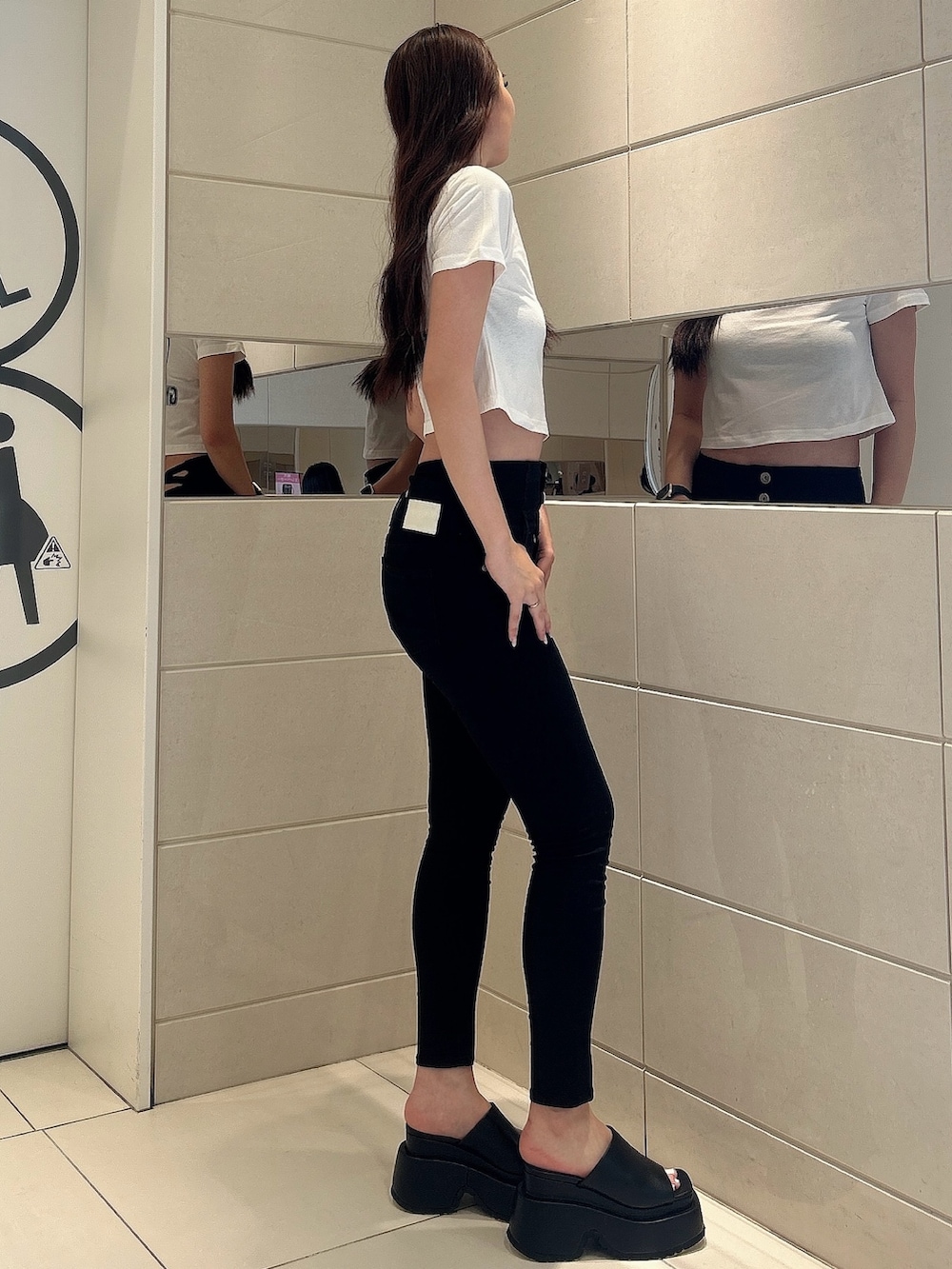 ホワイト系のTシャツ/カットソー、ブラック系のデニムパンツ、ブラック系のサンダルを着用したレディースの夏コーディネートの2枚目の写真