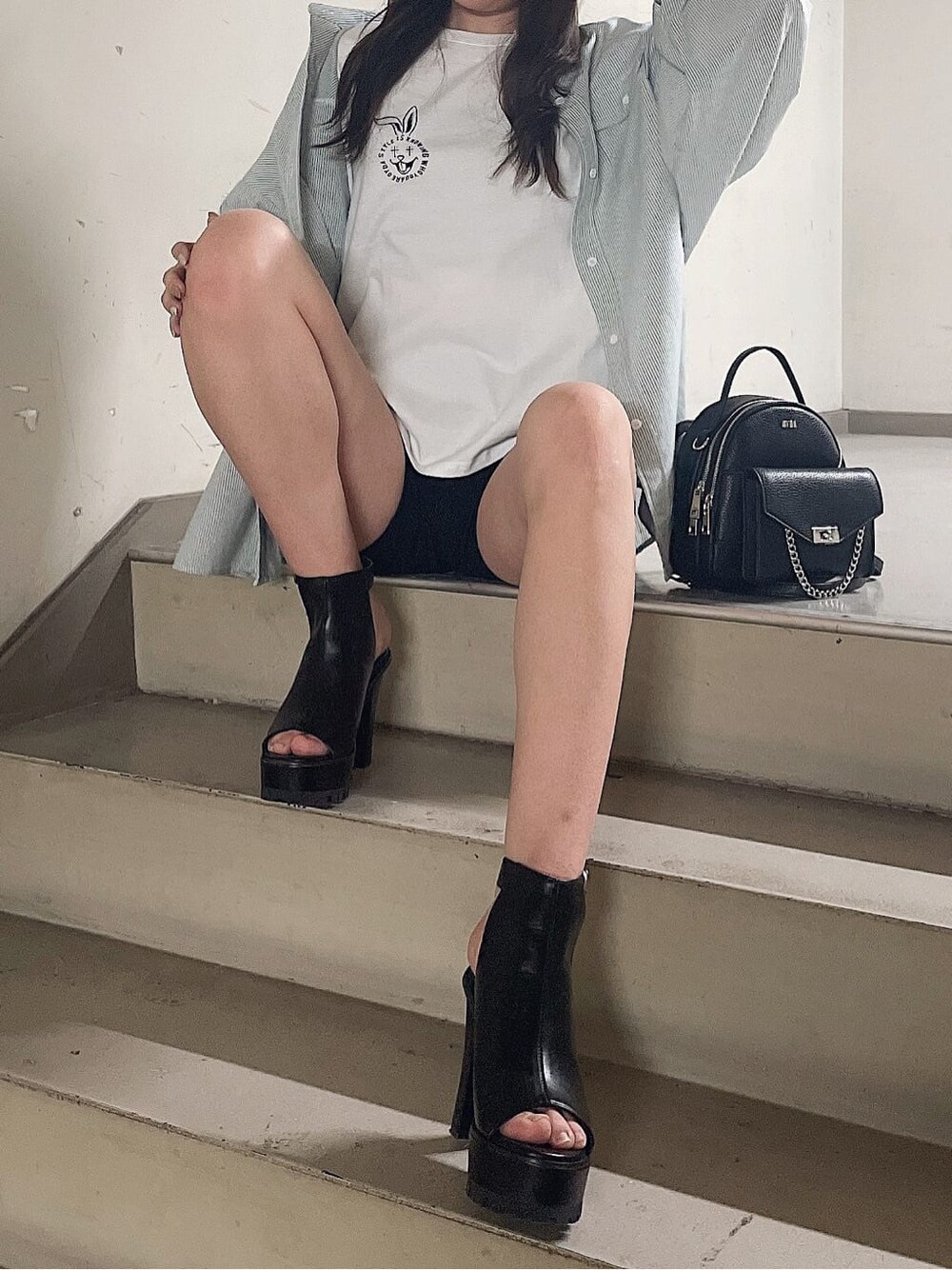 グリーン系のシャツ/ブラウス、ブラック系のバックパック/リュック、ブラック系のブーツを着用したレディースの春コーディネートの6枚目の写真