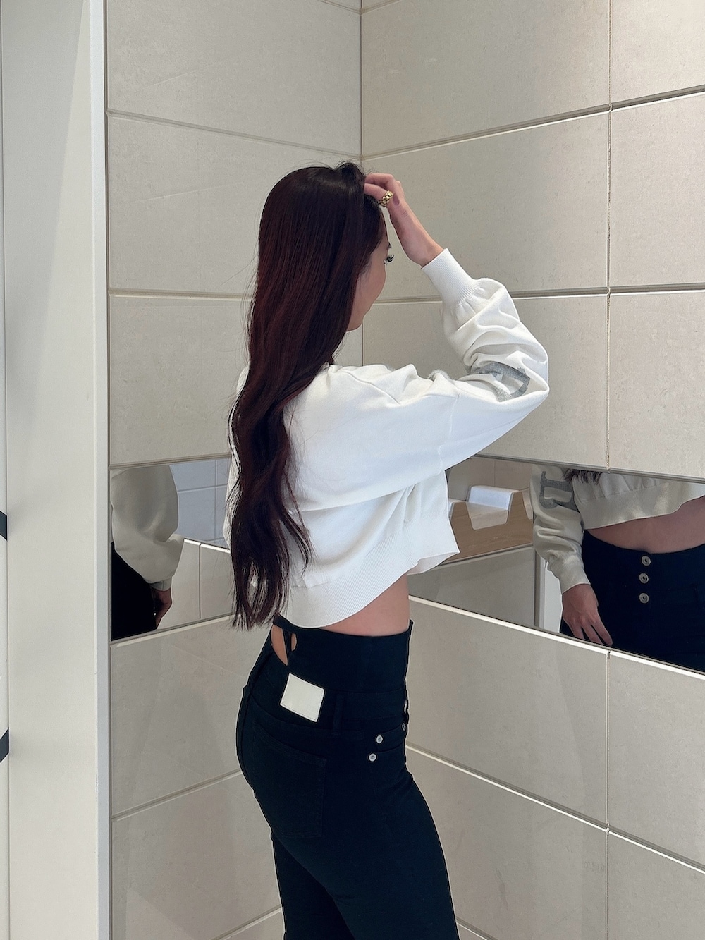 ホワイト系のニット/セーター、ブラック系のデニムパンツ、ブラック系のブーツを着用したレディースの冬コーディネートの5枚目の写真