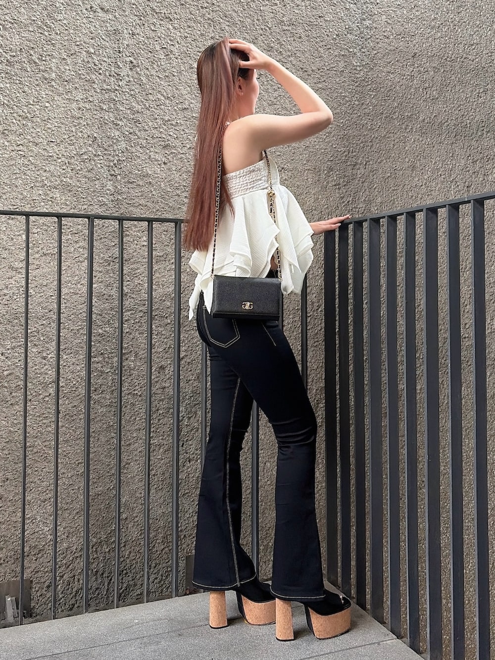 ホワイト系のキャミソール、ブラック系のデニムパンツ、ブラック系のサンダルを着用したレディースの夏コーディネートの2枚目の写真