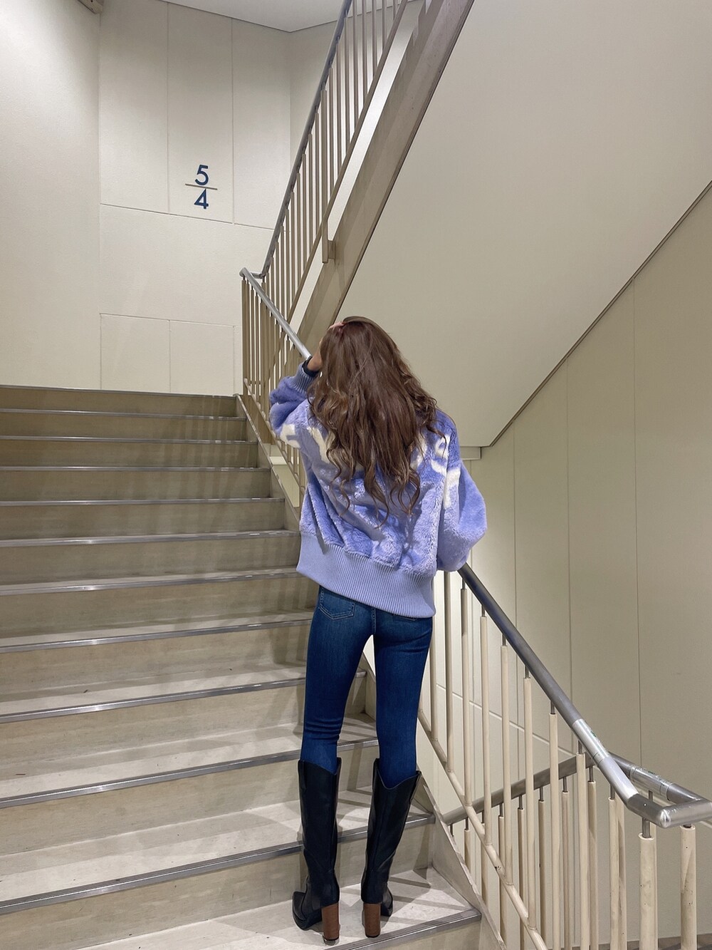 ブラック系のブーツ、ブルー系のデニムパンツ、ホワイト系のTシャツ/カットソーを着用したレディースの秋コーディネートの3枚目の写真