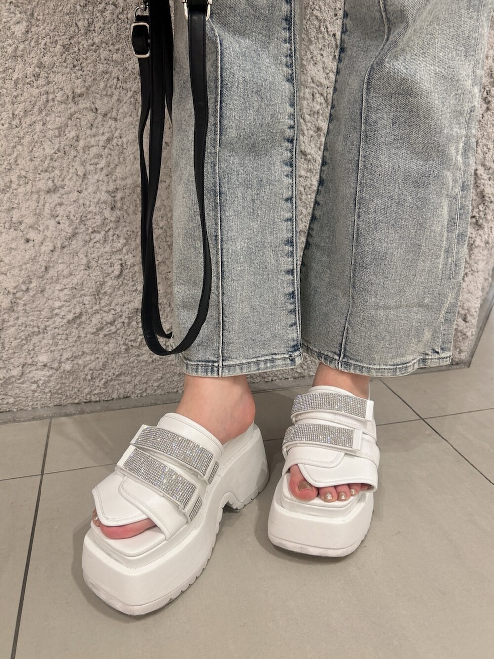 グリーン系のニット/セーター、ブルー系のつなぎ/オールインワン、ブラック系のバックパック/リュックを着用したレディースの春コーディネートの8枚目の写真