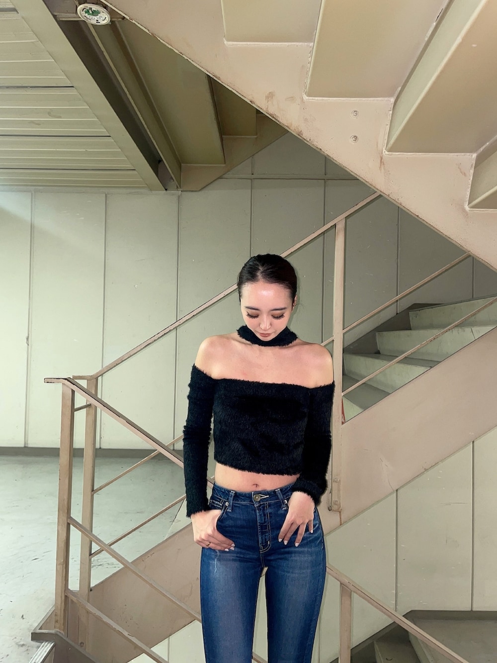 ブルー系のデニムパンツ、ブラック系のニット/セーター、ブラック系のパンプスを着用したレディースの秋コーディネートの3枚目の写真