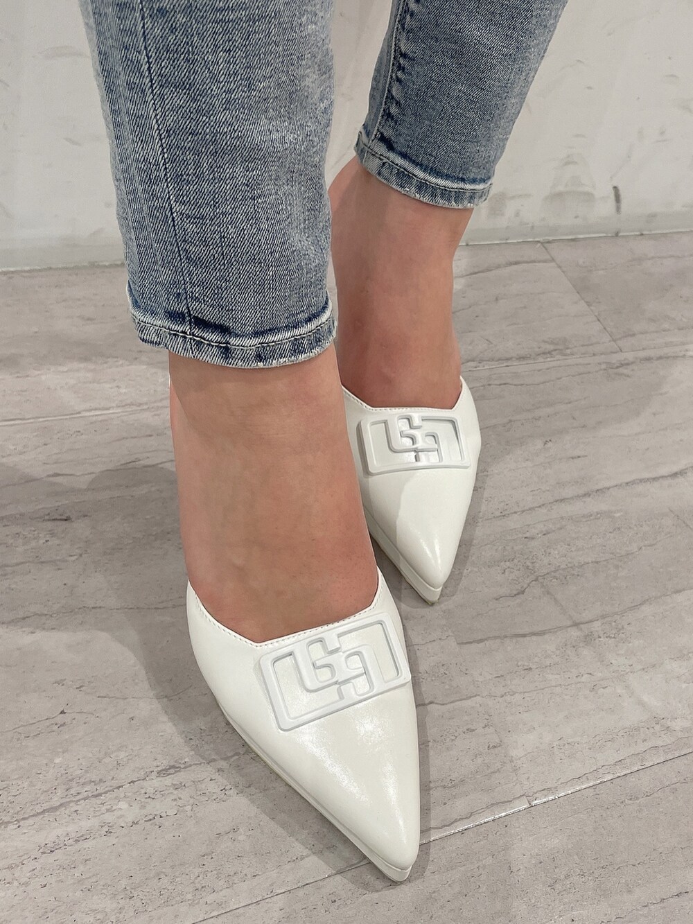 ホワイト系のパンプス、ブルー系のデニムパンツ、ブルー系のニット/セーターを着用したレディースの春コーディネートの7枚目の写真