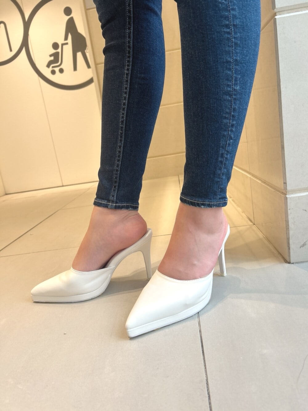 ブルー系のデニムパンツ、ホワイト系のパンプス、ブラック系のニット/セーターを着用したレディースの冬コーディネートの7枚目の写真