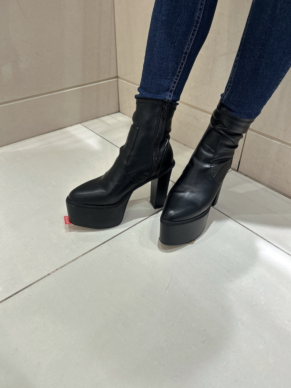 グリーン系のニット/セーター、ブルー系のデニムパンツ、ブラック系のブーツを着用したレディースの冬コーディネートの7枚目の写真