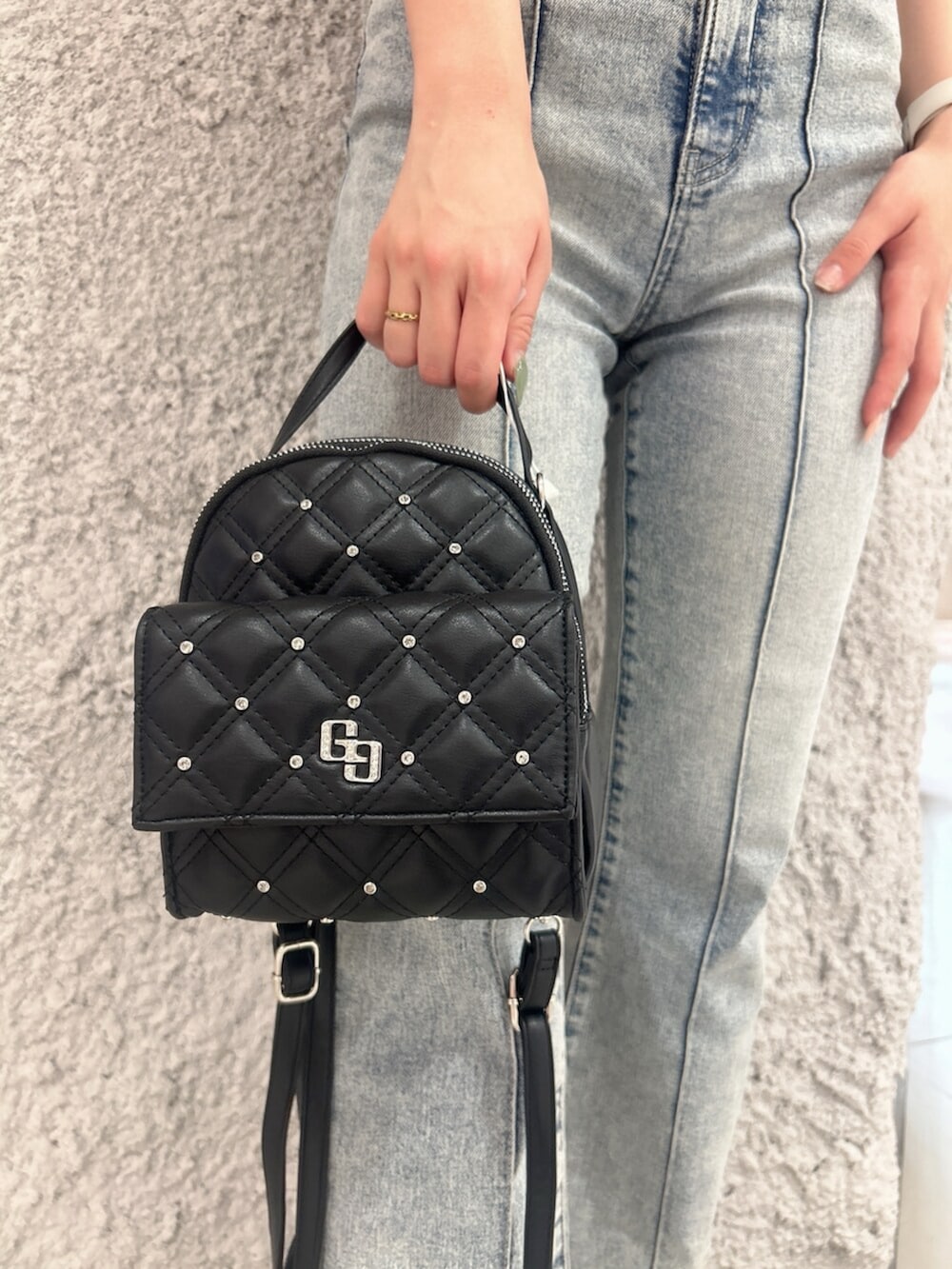 グリーン系のニット/セーター、ブルー系のつなぎ/オールインワン、ブラック系のバックパック/リュックを着用したレディースの春コーディネートの7枚目の写真