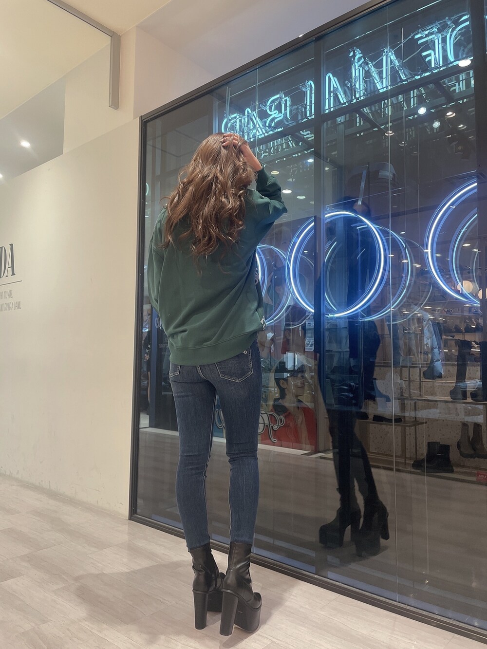 ホワイト系のTシャツ/カットソー、ブルー系のデニムパンツ、ブラック系のブーツを着用したレディースの冬コーディネートの3枚目の写真