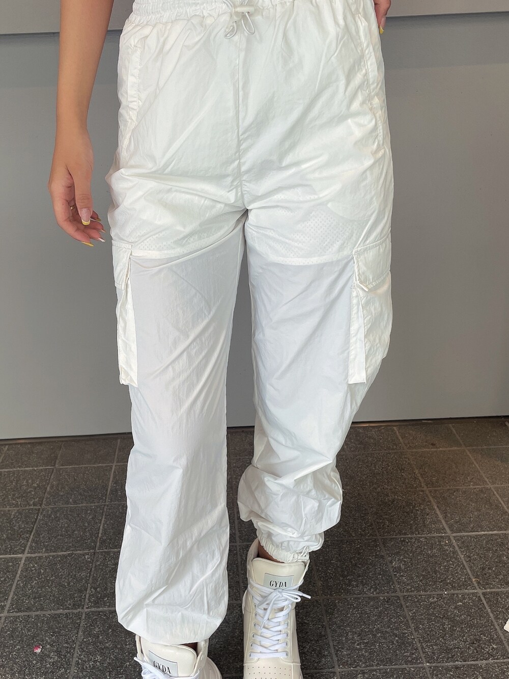 ホワイト系のスニーカー、ホワイト系のカーゴパンツ、ピンク系のTシャツ/カットソーを着用したレディースの夏コーディネートの8枚目の写真