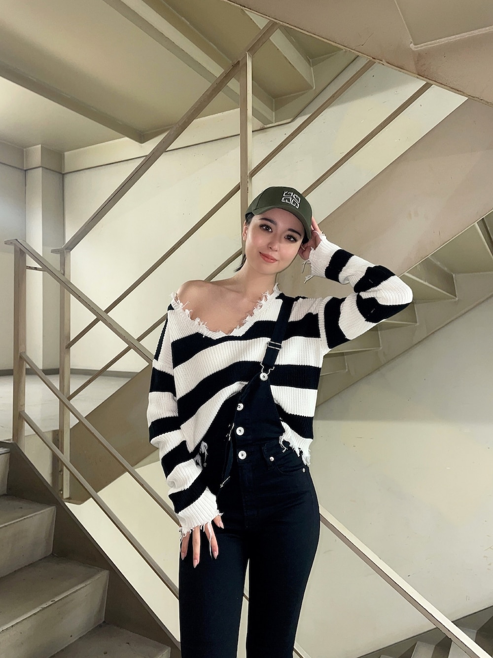 ブラック系のニット/セーター、ブラック系のサロペット/オーバーオール、ブラック系のパンプスを着用したレディースの冬コーディネートの4枚目の写真