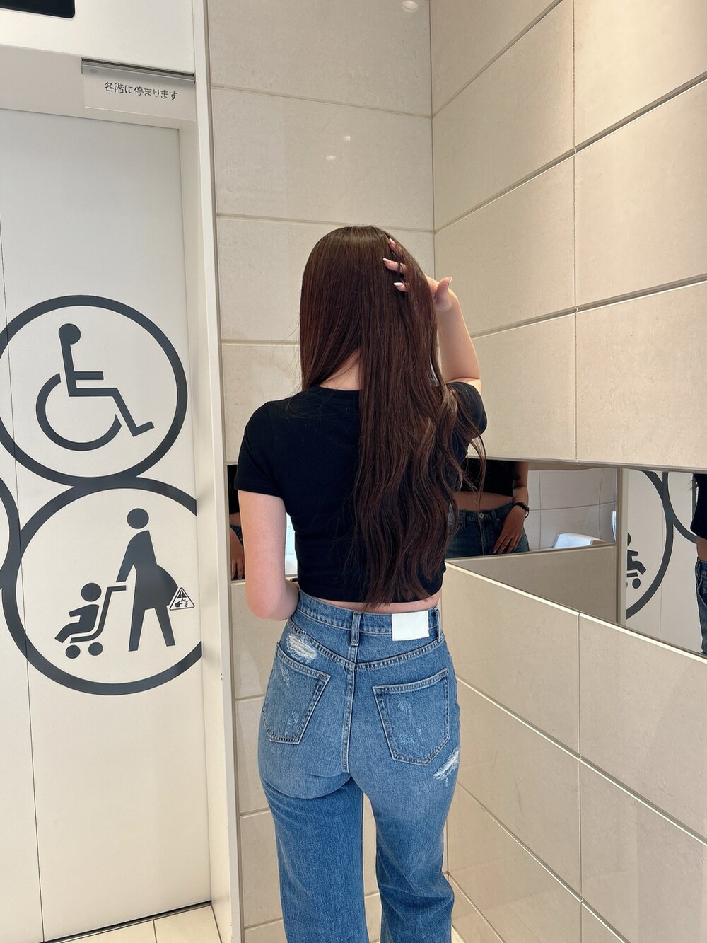 ブラック系のTシャツ/カットソー、ブルー系のデニムパンツ、ブラック系のハンドバッグを着用したレディースの春コーディネートの6枚目の写真