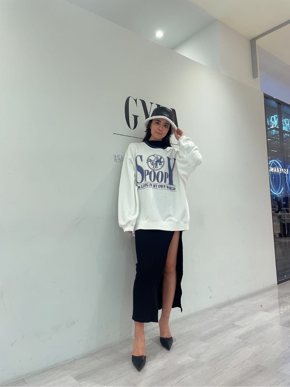 ホワイト系のスウェット、ブラック系のパンプス、ブラック系のワンピースを着用したレディースの秋コーディネートの4枚目の写真