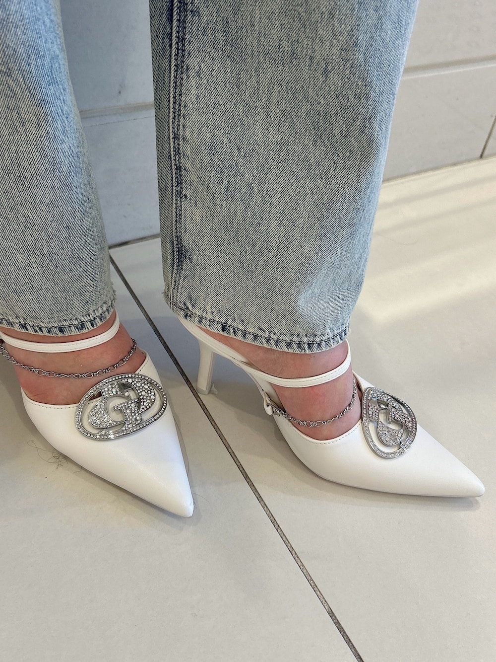 ホワイト系のパンプス、ブルー系のデニムジャケット、ホワイト系のキャミソールを着用したレディースの春コーディネートの8枚目の写真