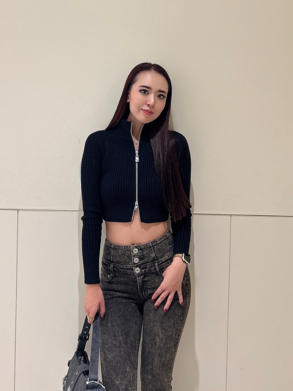 ブラック系のニット/セーター、ブルー系のデニムパンツ、グレー系のショルダーバッグを着用したレディースの秋コーディネートの4枚目の写真