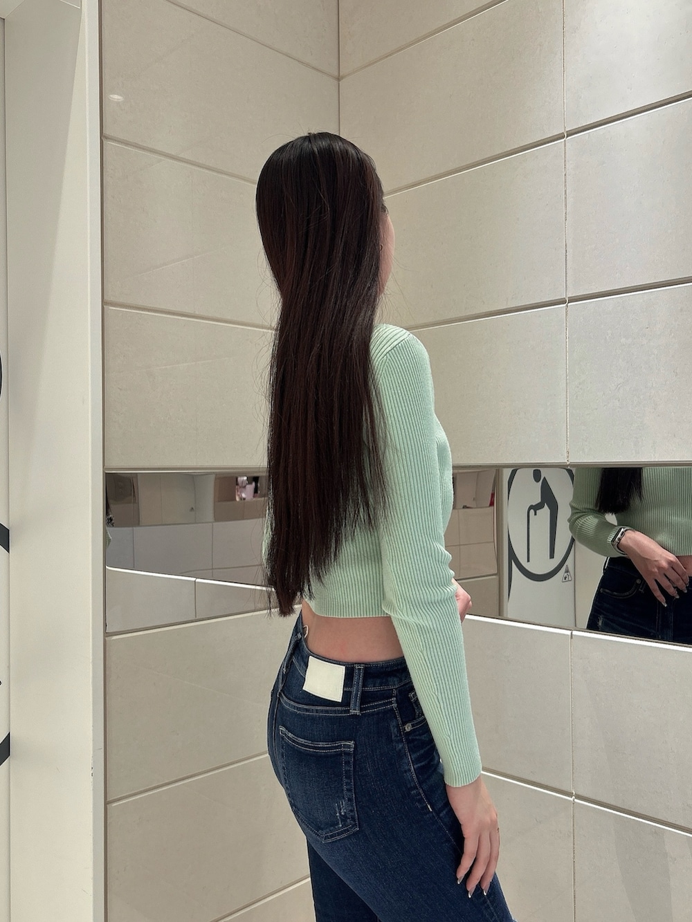 グリーン系のニット/セーター、ブルー系のデニムパンツ、ブラック系のブーツを着用したレディースの冬コーディネートの5枚目の写真