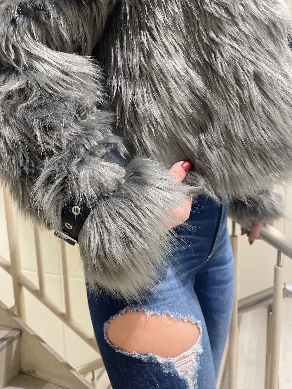 ブルー系のデニムパンツ、ホワイト系のニット/セーター、グレー系のライダースジャケットを着用したレディースの秋コーディネートの7枚目の写真