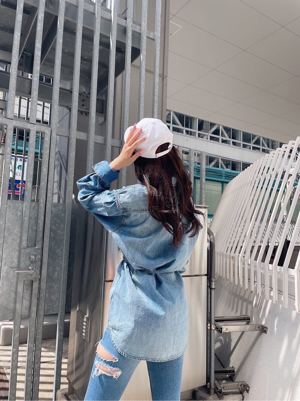 ホワイト系のパンプス、ブルー系のデニムパンツ、ブルー系のシャツ/ブラウスを着用したレディースの春コーディネートの3枚目の写真